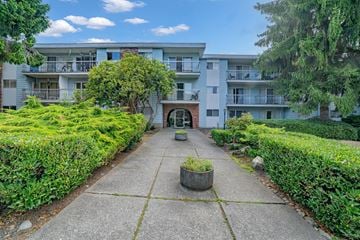 White Rock apartment for rent - A concrete walkway leads to a building with a brick archway.