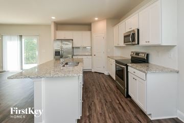 Charlotte house for rent - A kitchen with white cabinets and a granite countertop.