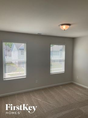 Charlotte house for rent - a bedroom with two windows and a carpeted floor