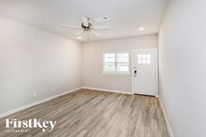 Lewisville house for rent - a bedroom with white walls and a white door and a ceiling fan