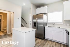 Lewisville house for rent - a kitchen with white cabinets and a stainless steel refrigerator