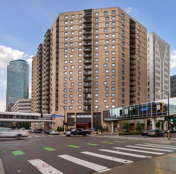 Minneapolis apartment for rent - a view of a city street with tall buildings and a train