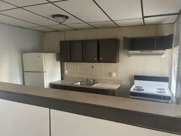 Chester apartment for rent - A kitchen with a white refrigerator, brown cabinets, and a stove top oven.