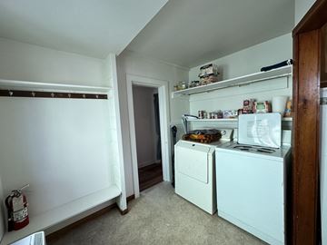 Sitka house for rent - A small kitchen with a white fridge and a white dishwasher.