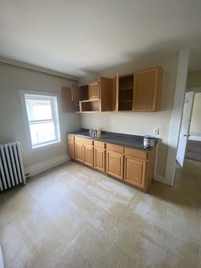 Bridgeport apartment for rent - an empty kitchen with wooden cabinets and a window