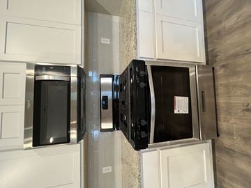 Youngsville house for rent - A black microwave oven is installed in a kitchen.
