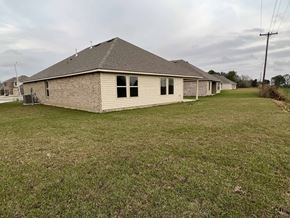 Youngsville house for rent - A house with a grey roof and a brown brick exterior sits in a grassy yard.