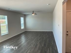 Greenville house for rent - an empty living room with wood floors and a ceiling fan