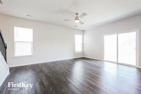 Simpsonville house for rent - A spacious room with wooden floors and a ceiling fan.