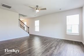 Simpsonville house for rent - A spacious room with wooden floors and a staircase.