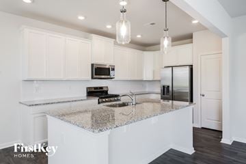 Simpsonville house for rent - A kitchen with a granite countertop and a microwave on it.