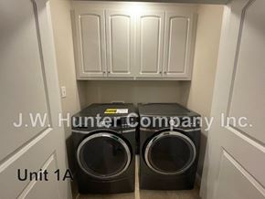 Wilson apartment for rent - Two black washing machines are in a white laundry room.