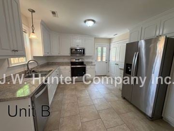 Wilson apartment for rent - A kitchen with white cabinets and a stainless steel refrigerator.