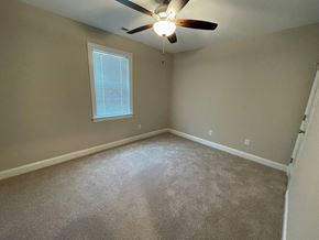 Wilson apartment for rent - A room with a ceiling fan and a window.