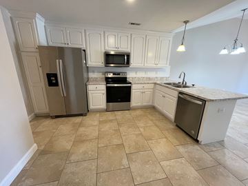 Wilson apartment for rent - A kitchen with a refrigerator, oven, and microwave.