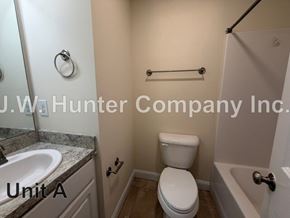 Wilson apartment for rent - A bathroom with a toilet, sink, and towel rack.