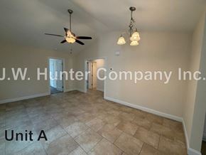 Wilson apartment for rent - A room with a ceiling fan and light fixture, and a doorway leading to another room.