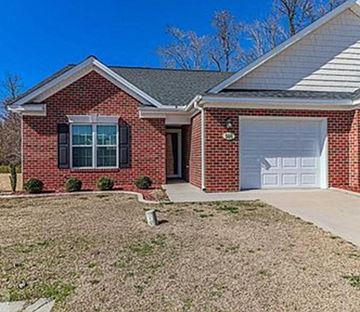 Goldsboro house for rent - A red brick house with a white garage door.