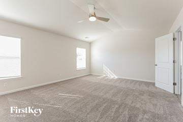 Greenville house for rent - a spacious living room with carpet and a ceiling fan