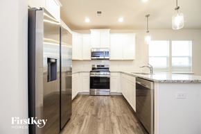 Greenville house for rent - a kitchen with white cabinets and stainless steel appliances