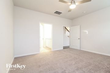 Greenville house for rent - a spacious living room with carpet and a ceiling fan