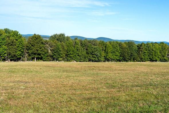 Brookings apartment for rent - a field of grass and trees with mountains in the background