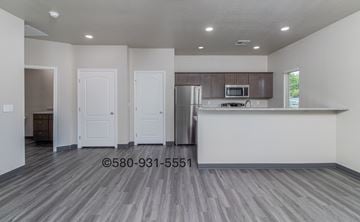 Durant apartment for rent - A kitchen with a refrigerator, microwave, and cabinets.