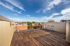 Washington apartment for rent - A wooden deck with two chairs and a table on a rooftop.