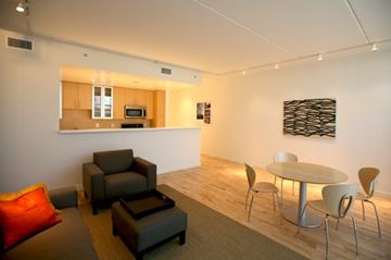 Washington apartment for rent - A modern living room with a grey couch and a white table.