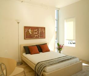 Washington apartment for rent - A bedroom with a bed, chair, and painting on the wall.