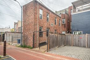 Washington apartment for rent - A red brick building with a black gate in front.