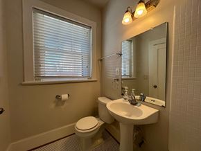 Roanoke apartment for rent - A bathroom with a toilet, sink, and mirror.