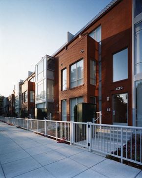 Washington apartment for rent - a row of brick buildings with a sidewalk and a white fence