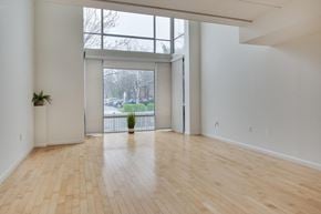 Washington apartment for rent - A room with wooden floors and a large window overlooking a yard.
