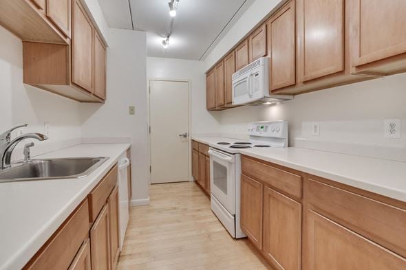 Washington apartment for rent - A kitchen with wooden cabinets and a white stove top oven.