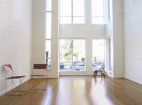 Washington apartment for rent - Two chairs sit in a white room with large windows.