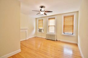Washington apartment for rent - A room with a ceiling fan and a window with blinds.