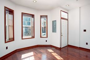 Washington apartment for rent - a room with wood floors and three windows and a white door