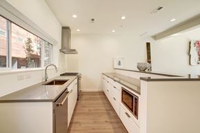 Washington apartment for rent - a large white kitchen with stainless steel appliances and a large window