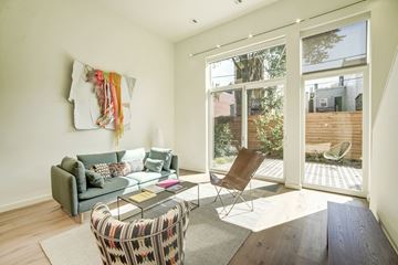 Washington apartment for rent - A living room with a grey couch, a chair, a coffee table and a window.