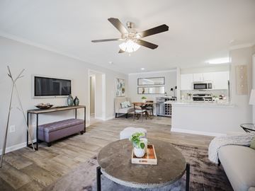 Newnan apartment for rent - A living room with a brown coffee table and a flat screen TV mounted on the wall.