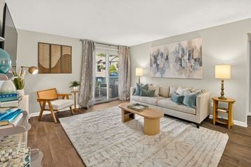 Augusta apartment for rent - A living room with a white couch, a wooden chair, a coffee table, and a painting on the wall.