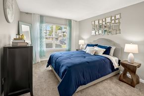 Augusta apartment for rent - A bedroom with a blue bedspread and a wooden side table.