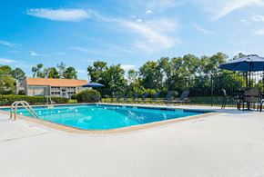 Augusta apartment for rent - A large swimming pool with a blue sky and trees in the background.