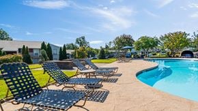 Augusta apartment for rent - A pool surrounded by lawn chairs and trees.