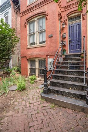 Washington apartment for rent - the front of a red brick building with stairs and a blue door
