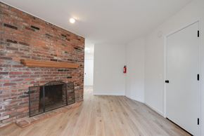 Washington apartment for rent - a living room with a brick fireplace and wooden floors