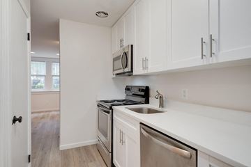 Washington apartment for rent - a kitchen with white cabinets and a sink and a microwave