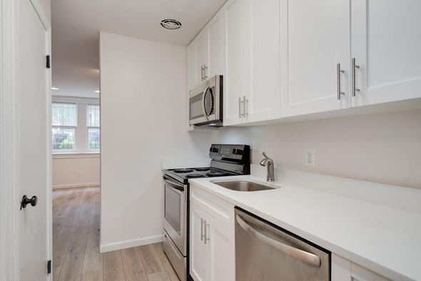 Washington apartment for rent - a kitchen with white cabinets and a sink and a microwave