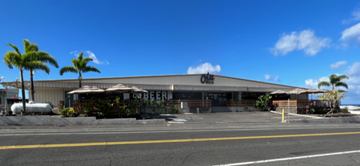 Kailua-Kona apartment for rent - an old building with palm trees on the side of a street